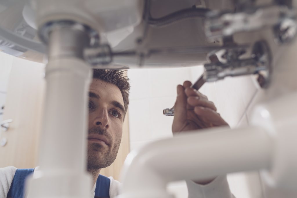 Commercial plumber and tradesman conducting repairs